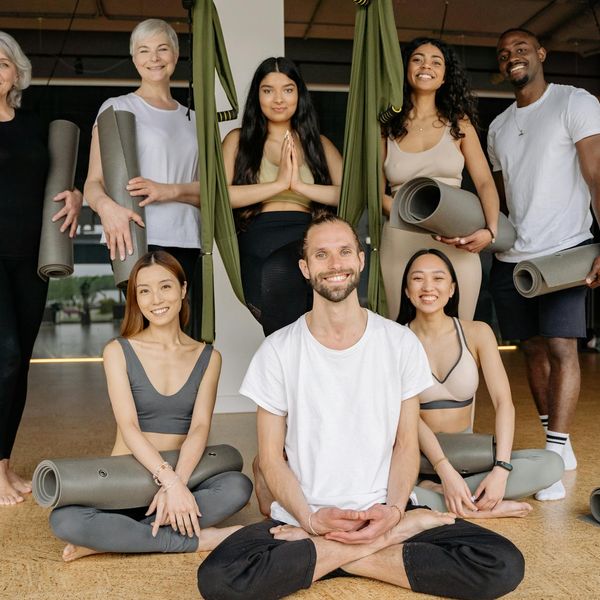 Group of people in a bright studio, smiling after a yoga class.